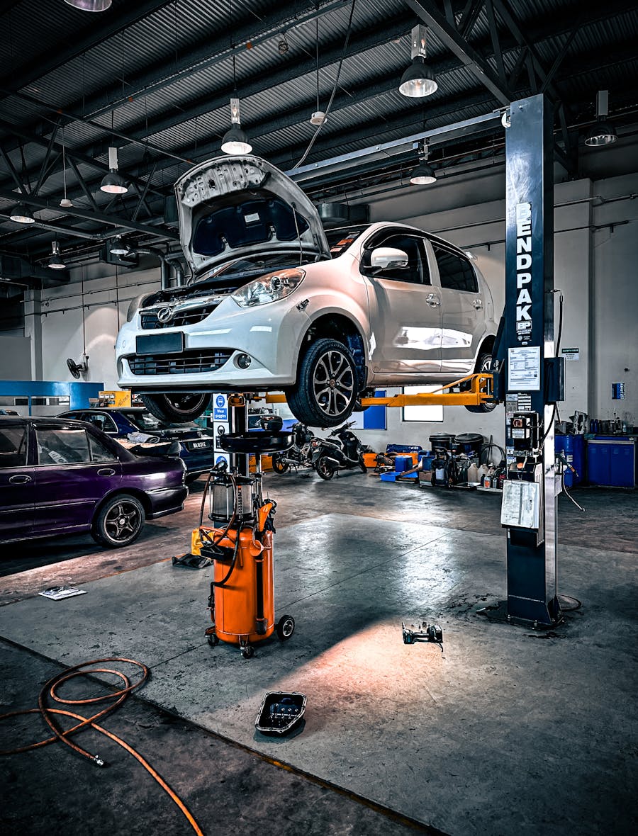 A vehicle raised on a hydraulic lift in a well-equipped AMBER FALCON service bay